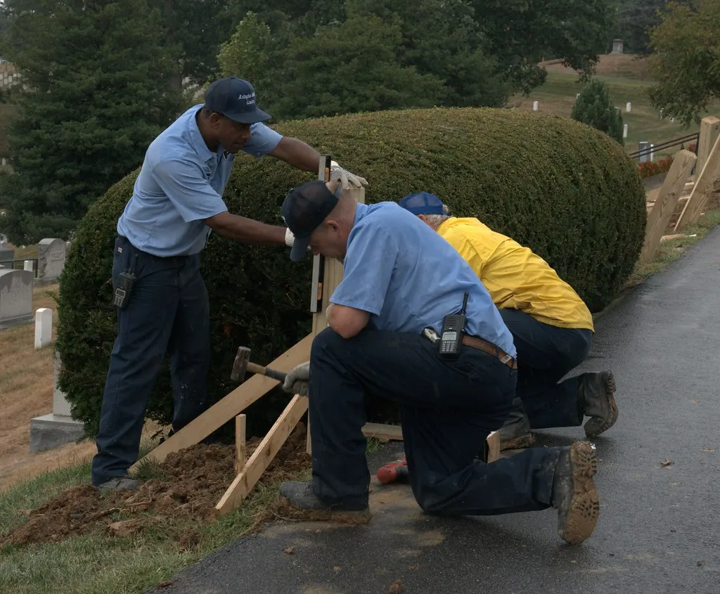 Workers setting a fence post